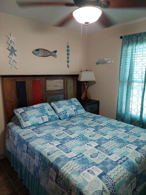 A bedroom with a bed, a ceiling fan, decorative wall art, and a window with curtains. - NEW LISTING! Minutes away from Beach, Intercoastal, & boat ramp. Great Fishing! (Sargent)