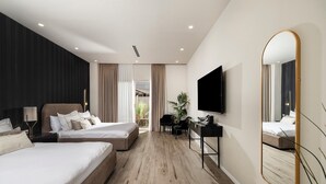 Una habitación de hotel moderna con dos camas, un escritorio, un televisor de pantalla plana y un espejo grande.