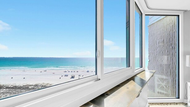 A beach view from a room with large windows, a wooden bench, and a textured wall. - 🌴Gulf Views- Beachside Pool- Studio Top of the Gulf 813🌴 (Panama City Beach)