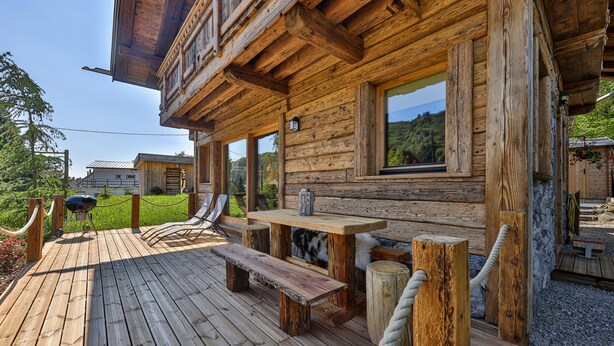 A wooden deck with a table and benches, surrounded by a rope fence. - Chalet Hohneck 4**** old wood and stone, SPA, sauna, charging station (Stosswihr)