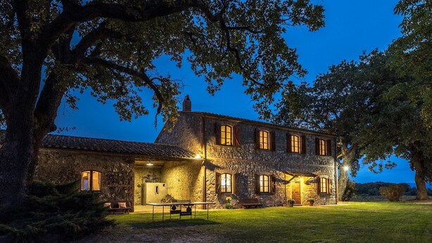A stone building with multiple windows and a well-lit exterior.