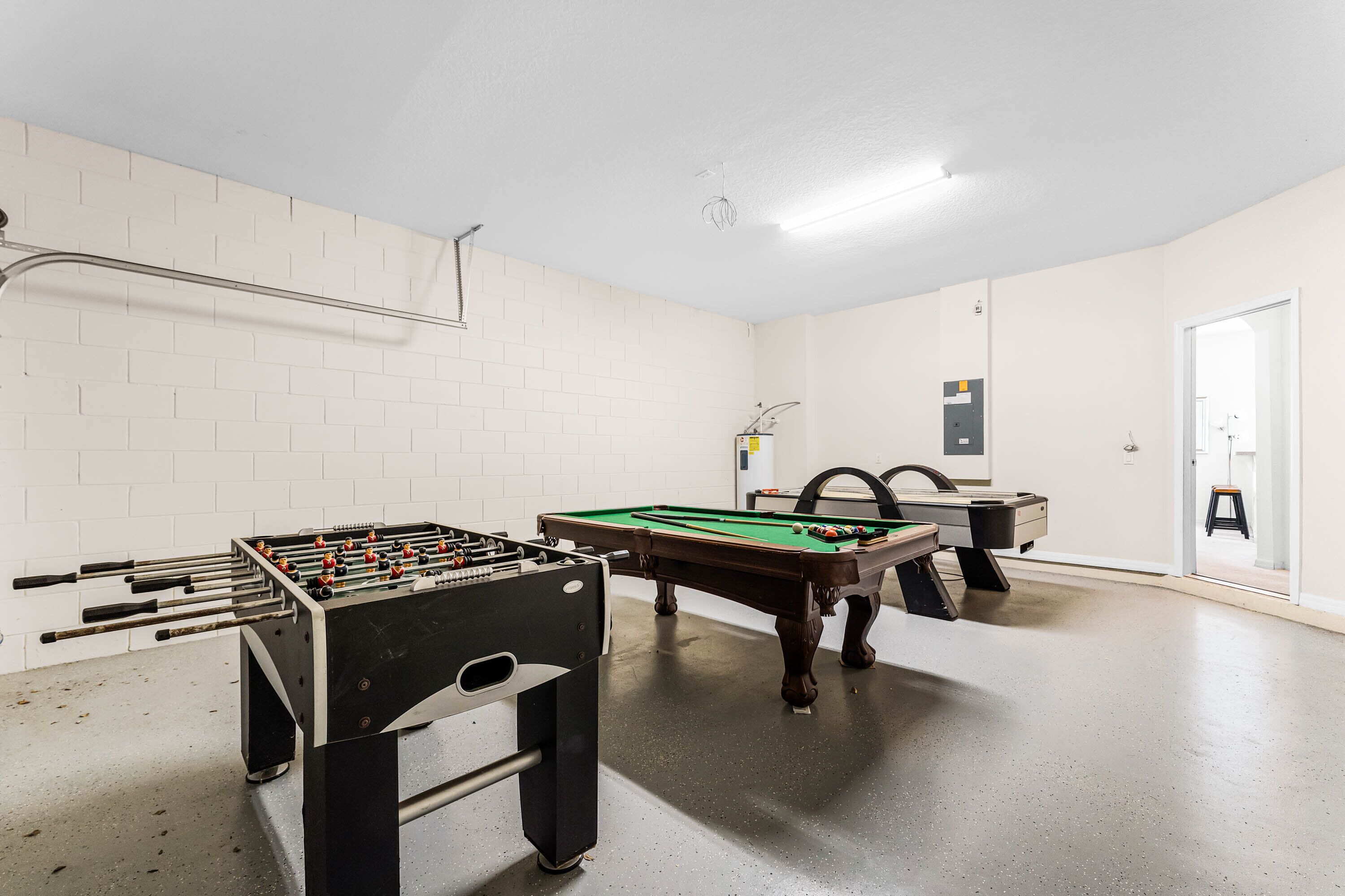 Une pièce équipée d’un baby-foot, d’une table de billard et d’un coin bar.