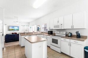 Enjoy cooking in this well-equipped kitchen with a refrigerator, microwave, oven, and coffee maker.