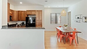 A modern kitchen with wooden cabinets, a black refrigerator, and a granite countertop. - Bright 3BR Home / East ATX / Cowboy Pool / Near UT (Austin)