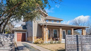 A two-story house with a stone facade, a covered porch, and a garage. - Bright 3BR Home / East ATX / Cowboy Pool / Near UT (Austin)