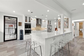 A spacious kitchen with a large island, modern appliances, and a view to the dining area.