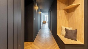 Un couloir avec un banc en bois et une vue sur une autre pièce.