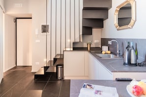 Een moderne keuken met een inbouwfornuis, een spoelbak en een koffiezetapparaat.