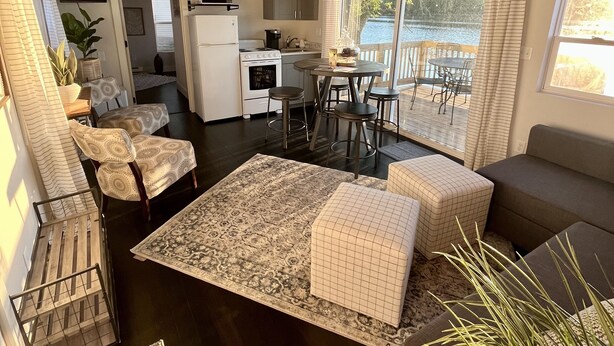 A compact living space with a kitchenette, dining area, and a balcony with a view.