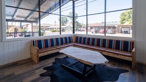 A modern interior with a large window, a wooden bench with colorful stripes, and a stone table. - Motolodge (Pendleton)