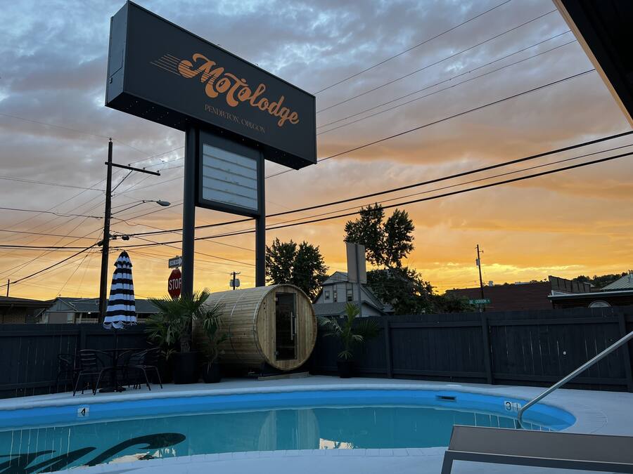 A motel sign, a swimming pool, and a wooden structure.