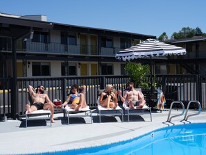 A pool area with lounge chairs and a pool.