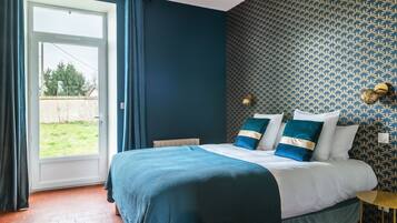 Une chambre à coucher avec un lit, une fenêtre et un mur décoré d’un motif.
