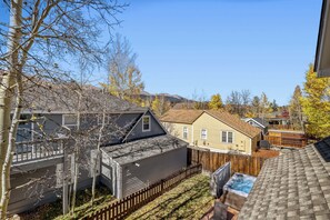 Ett bostadsområde med hus, ett trästaket och en klar himmel.