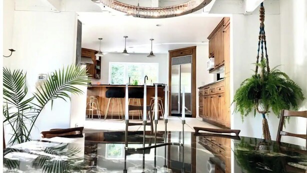 Una cocina moderna con armarios de madera, una isla central e iluminación colgante.