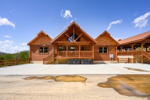 A wooden lodge with a central entrance, multiple windows, and a covered porch area.