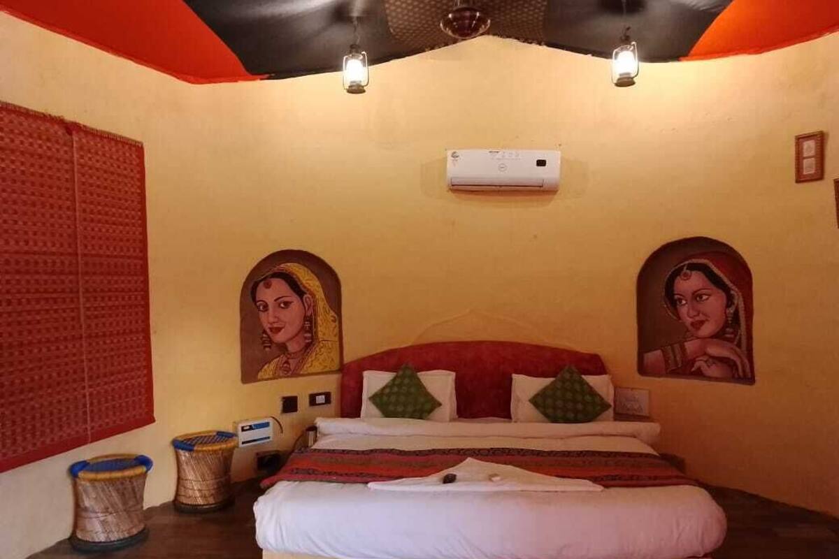 Quarto com uma cama, ventilador de teto e ar condicionado fixado na parede.
