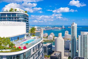 A modern hotel with a rooftop pool, a view of the city skyline, and the ocean. - Luxurious Condo in the Heart of Brickell (Miami)