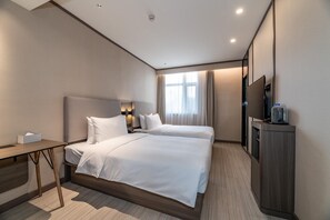 A hotel room with two beds, a desk, a flat-screen TV, and a minibar. - Hanting Hotel (Kuytun)