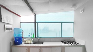 A kitchen with a window, sink, cabinets, and a gas stove.
