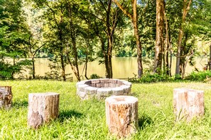 Relax by the serene lake surrounded by lush greenery and tall trees.