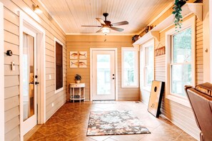 Traditional interior with a hallway, ceiling fan, and door to another room.