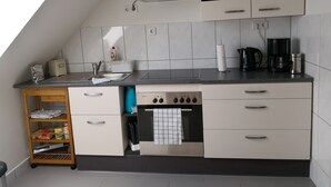 Une cuisine moderne avec des armoires blanches, un comptoir noir et un four encastré.