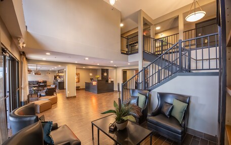 A spacious lobby with leather seating, a reception desk, and a staircase.
