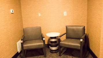 A small room with two leather chairs and a round table.