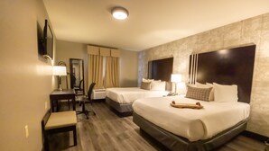 A hotel room with two beds, a desk, a chair, and a small bench. - Distill-Inn (Bardstown)