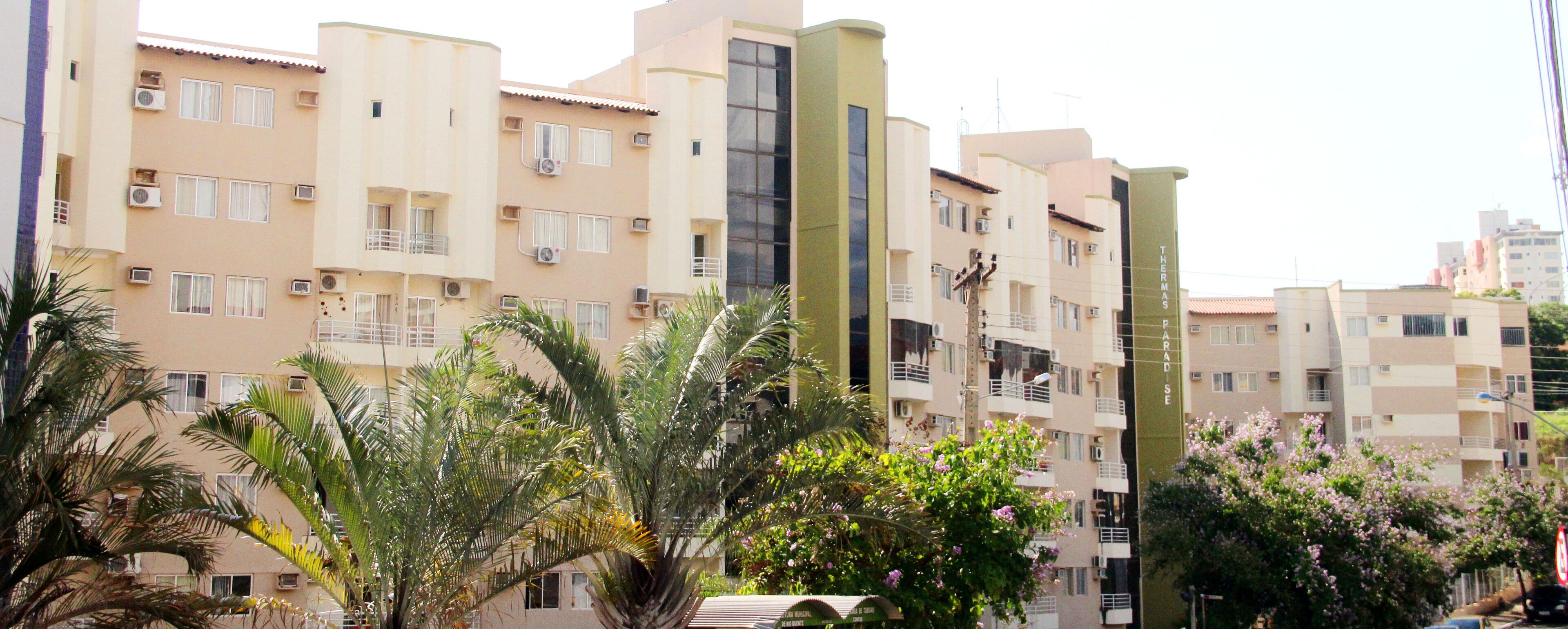 A multi-story residential building with balconies and air conditioning units.