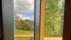 Une porte en bois avec une fenêtre, une poignée de porte en métal et un paillasson en métal.