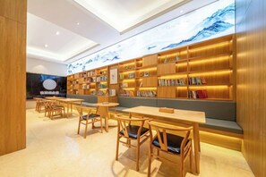 Una biblioteca con estanterías, asientos y mesas.