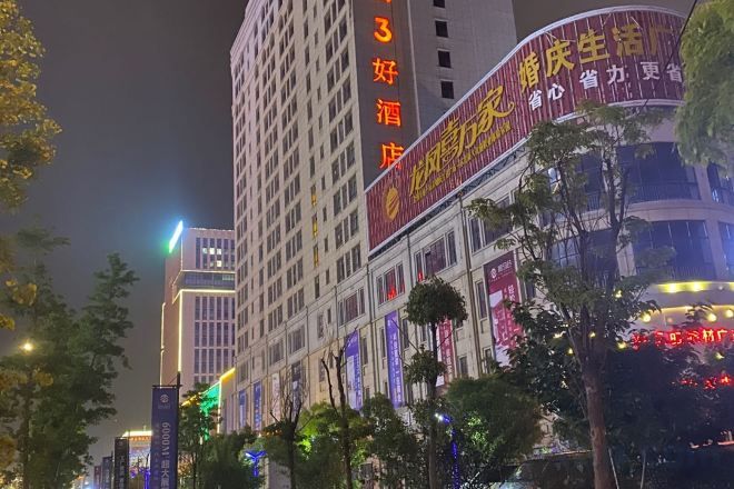 A multi-story building with illuminated signage, likely a hotel or commercial property.