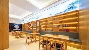 A modern library with wooden bookshelves, seating areas, and a large digital display. - Vienna 3 Best Hotel (Huai'an Huaiyin Normal University North Bus Station) (Huai'an)
