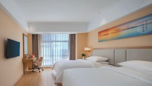 A hotel room with two beds, a desk, a chair, a TV, and a painting on the wall. - Vienna 3 Best Hotel (Huai'an Huaiyin Normal University North Bus Station) (Huai'an)