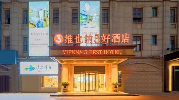 The Vienna 3 Best Hotel facade with illuminated signage and large banners. - Vienna 3 Best Hotel (Huai'an Huaiyin Normal University North Bus Station) (Huai'an)