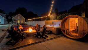 A patio area with a fire pit, outdoor seating, and a hot tub. - Miracle on 54th - Hot Tub, Sauna, and Pickleball (Cleveland)