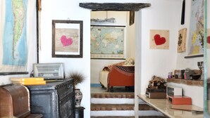 A cozy room with a vintage radio, a map, and a staircase leading to another level. - The pergola (old house) inside the history of Sardinia. (Gergei)