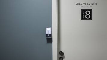 A door with a digital lock and a sign indicating "Villa Am Bahnhof" and "Apartment 8".