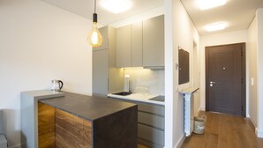 Eine moderne Küche mit einer zentralen Kochinsel, integrierten Geräten und einem Holzkasten.