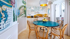 A dining area with a round table, wicker chairs, and a bowl of lemons. - Estate4home - Casa Nonna Mary (Positano)