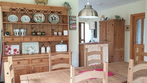 A kitchen with wooden cabinets, a table, chairs, and various kitchenware. - Cottage on Lough Ree / River Shannon in the heart of Ireland (Newtowncashel)