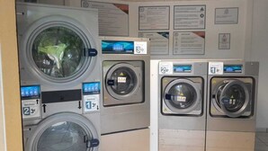 A laundry facility with multiple washing machines, each labeled with a price tag.