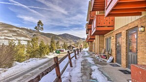 Un bâtiment doté d’un balcon en bois, de murs en briques et offrant une vue sur des montagnes enneigées.