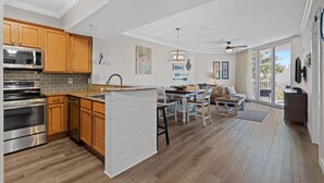 A modern kitchen with wooden cabinets, stainless steel appliances, and a large island. - A Wave Away 1206-Near Beach-Sleeps 6 (Destin)