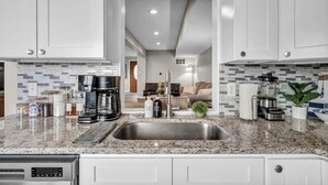 A modern kitchen with granite countertops, stainless steel appliances, and a central island.