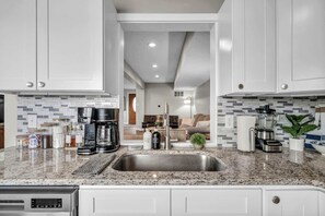 A modern kitchen with granite countertops, stainless steel appliances, and a central island.