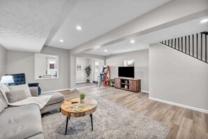A spacious living room with a sofa, coffee table, and TV.