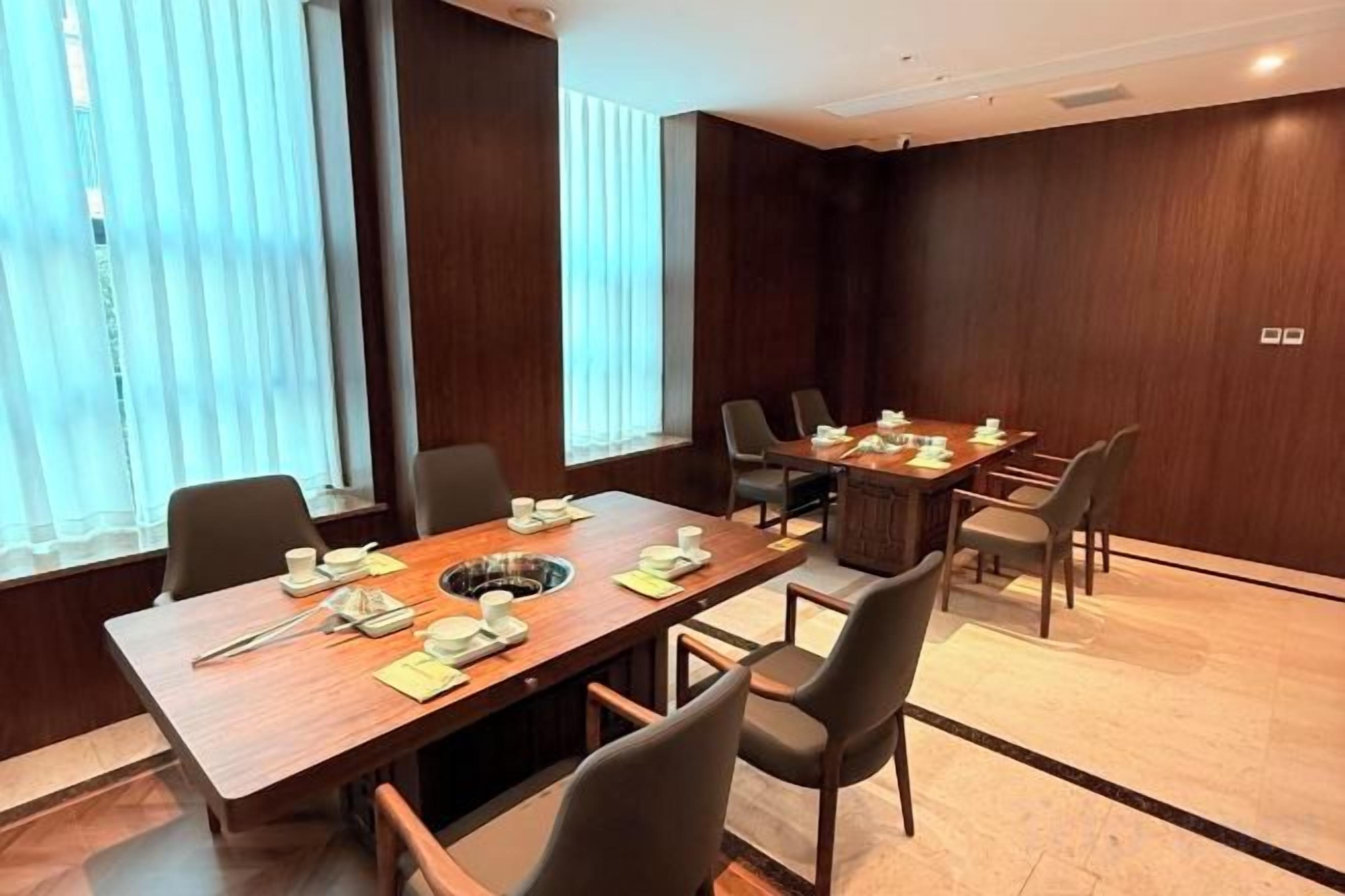 A conference room with a long table, chairs, and a projector screen.